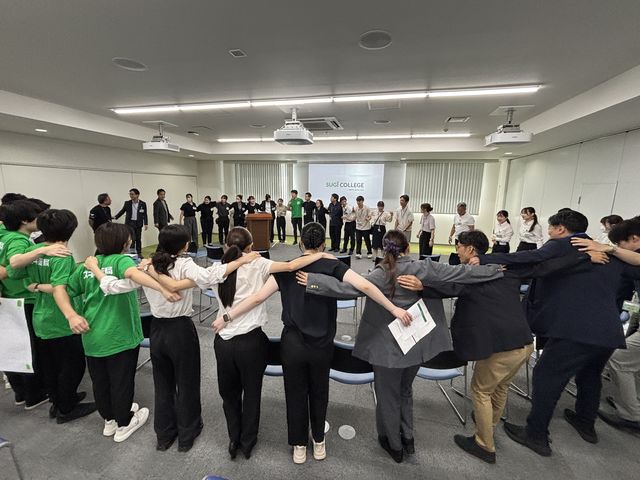 オープニングで肩を組む学生と社員