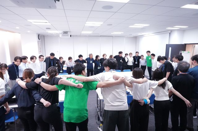 オープニングで肩を組む学生と社員