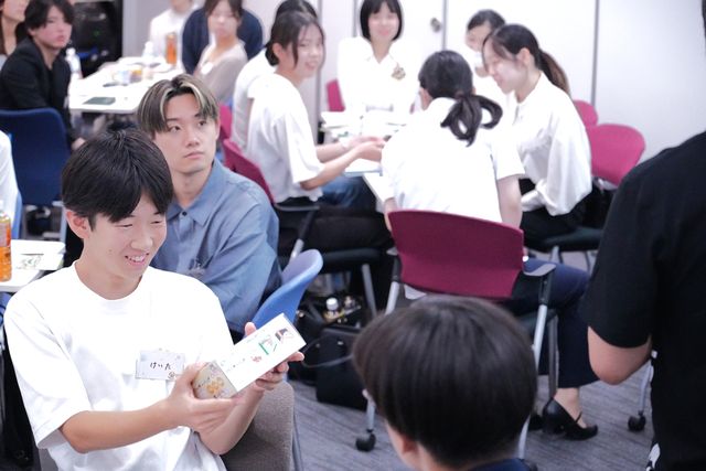 カードを手に笑う学生